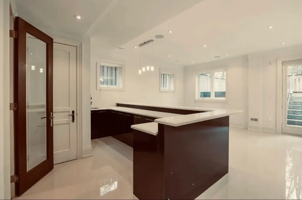 Basement bar renovation by Renotec with custom cabinets, countertop, and herringbone flooring