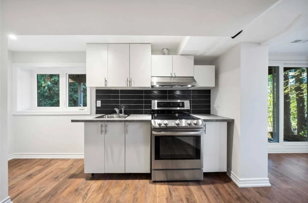 Basement kitchen renovation by Renotec with white cabinets and modern finishes