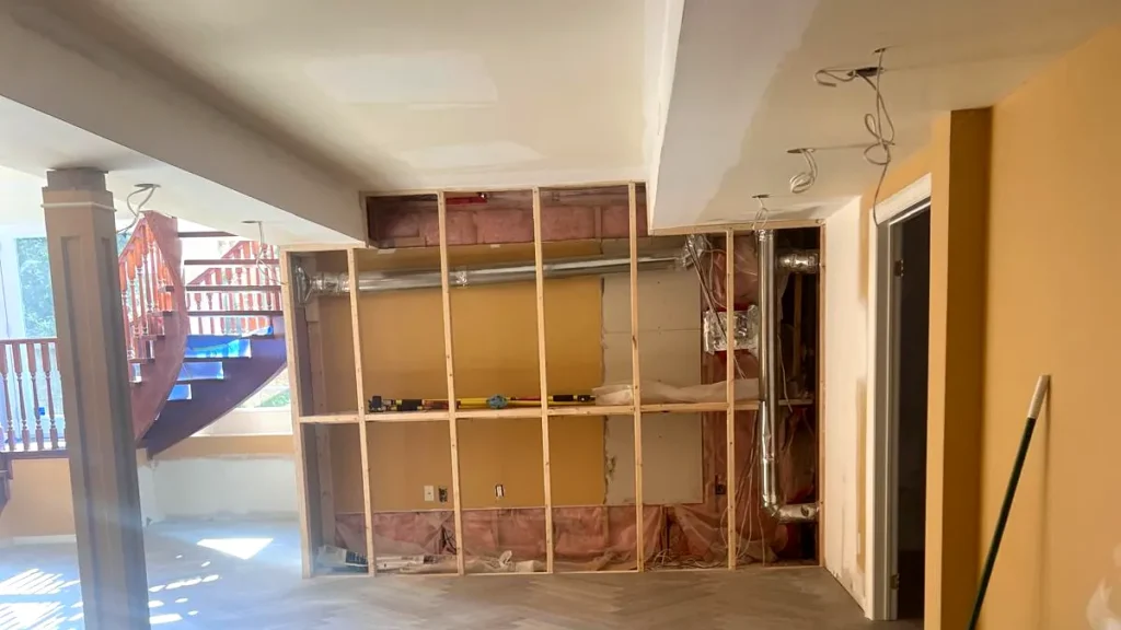 Basement renovation in progress by Renotec showing framing, flooring, and ceiling preparation