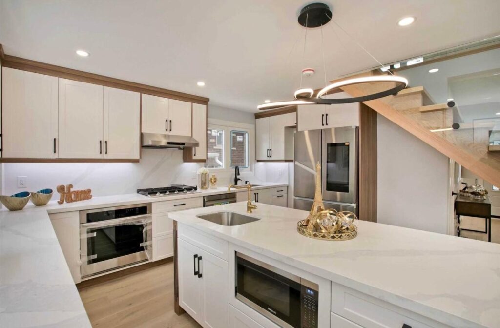 Custom kitchen renovation in Richmond Hill with white and wood cabinets, island, and modern lighting