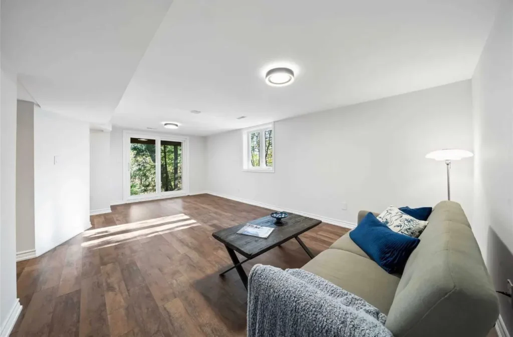 Finished basement living room renovation by Renotec with bright windows and modern flooring