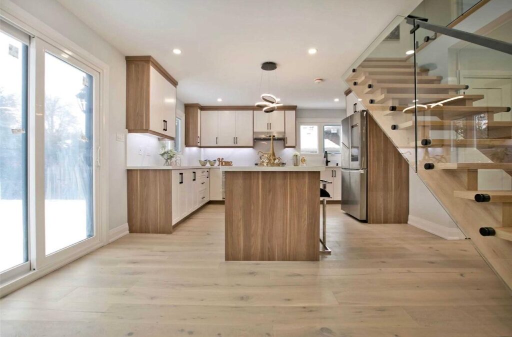 Open-concept kitchen renovation in the GTA with island, glass stair railing, and custom cabinets